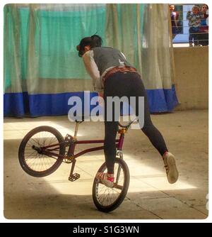 En regardant une jeune femme faisant des tours sur un vélo. Banque D'Images