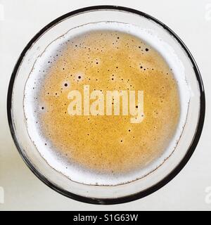 Un peu de mousse de la bière dans un verre en plongée des décisions d'un cercle Banque D'Images
