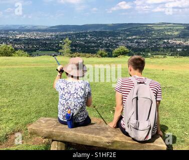 La mère et le fils assis sur le banc de la colline admiring view Banque D'Images