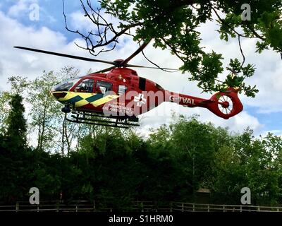 Le Thames Valley Air Ambulance atterrit sur un champ à l'Oxfordshire transporter un blessé à l'hôpital. Banque D'Images