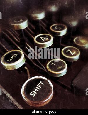 La touche Maj enfoncée et d'autres touches d'un clavier qwerty sur une ancienne machine à écrire. Banque D'Images