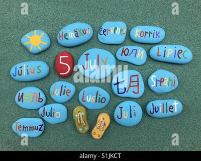 5 juillet, date du calendrier en plusieurs langues sur les pierres de couleur sur le sable vert Banque D'Images