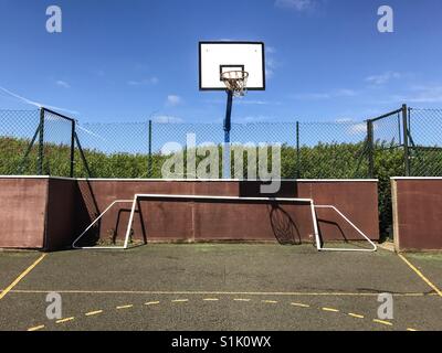 Un panier de basket-ball et un but de football sur un terrain de sport de la communauté en Angleterre. Banque D'Images