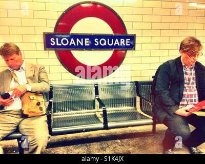 Assise sur un banc à la station de métro Sloane Square. Banque D'Images