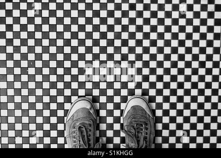 De haut en bas sur une paire de chaussures dans une chaussure sur un permanent selfies à carreaux noirs et blancs marbre Banque D'Images