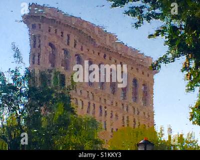 Le Flatiron building reflète dans une fontaine à proximité de Madison Square Park, NYC. Banque D'Images