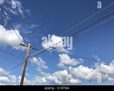 Ciel bleu avec des nuages et le poteau télégraphique Banque D'Images