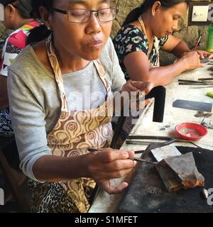 Les bijoutiers de sexe féminin travaillant en atelier. Ubud, Bali, Indonésie Banque D'Images