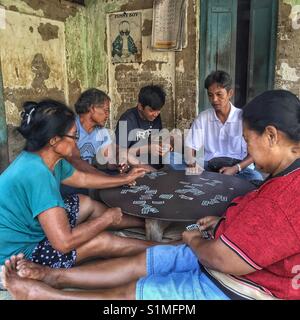 Groupe de cinq personnes assises les cartes à jouer. Bali, Indonésie Banque D'Images