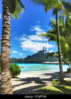 L'affichage classique sur le Mont Otemanu à Bora Bora, Polynésie française, avec des palmiers, plage et bungalows sur pilotis Banque D'Images