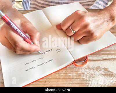 Femme écrit dans un journal de balle Banque D'Images