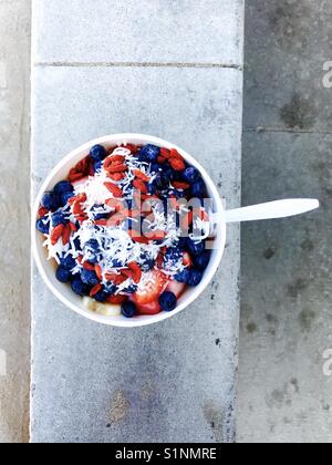 Un bol d'acai de bleuets, fraises, noix de coco et de copeaux. Banque D'Images