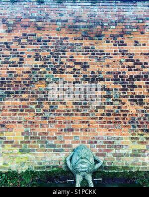 Sculpture Humpty Dumpty en face d'un mur de briques colorées Banque D'Images