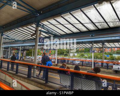 La gare de Guildford, les passagers sur la plate-forme et la banlieue de voitures stationnées au-delà Banque D'Images