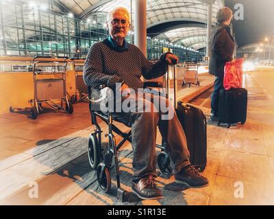 Hauts homme et une femme en attente de la navette de l'aéroport la nuit. El Altet Aéroport, Alicante, Espagne. Banque D'Images