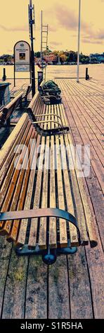 Personne sans-abri dormant sur un banc au bord de la jetée, Stockholm, Suède, Scandinavie Banque D'Images