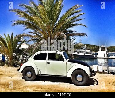 Un vieux modèle VW stationné à côté d'un palmier à la marina de Puerto Los Cabos, au Mexique. Banque D'Images