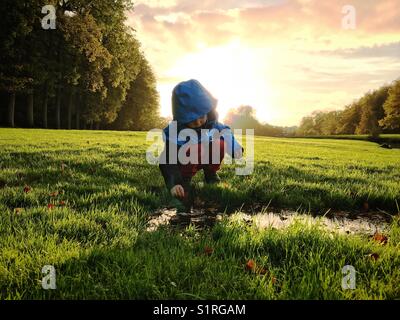 Boy playing in puddle Banque D'Images