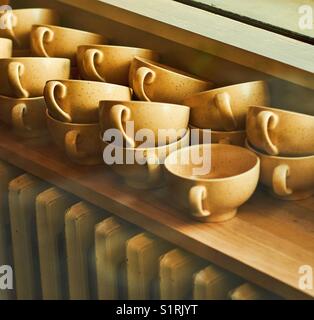 Une pile de tasses à café au-dessus d'un radiateur à l'ancienne Banque D'Images