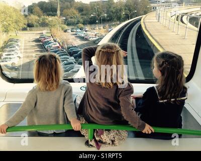 Trois sœurs, les filles, de monter à l'avant du train navette Gatwick entre terminal nord et sud.L'aéroport de Gatwick, Londres, UK Banque D'Images