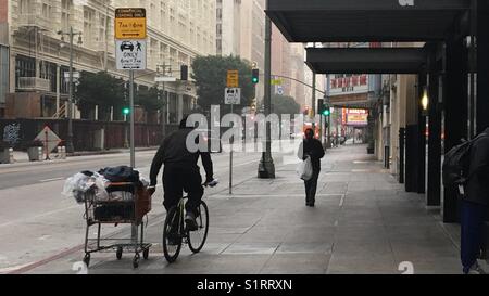 L'homme à vélo avec effets personnels dans un panier à Broadway dans le centre-ville de Los Angeles Banque D'Images