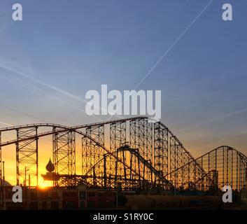 Lever du soleil à travers la structure de la tête de l'un rollercoaster sur Blackpool Pleasure Beach Banque D'Images