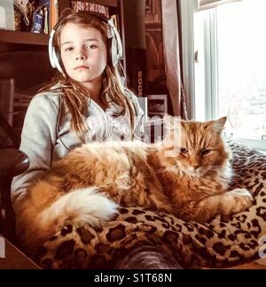 Portrait d'une jeune fille et sa grosse orange tabby cat pet Banque D'Images