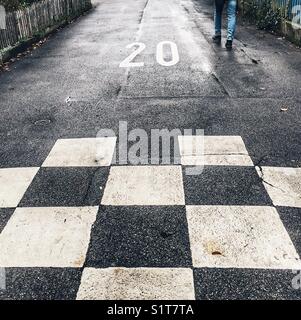 Motif en damier sur route avec limite de vitesse de 20 marquée Banque D'Images