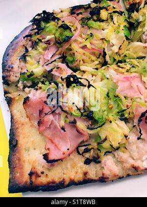 Pizza au pain plat avec choux de bruxelles rasés et garnitures au prosciutto Banque D'Images