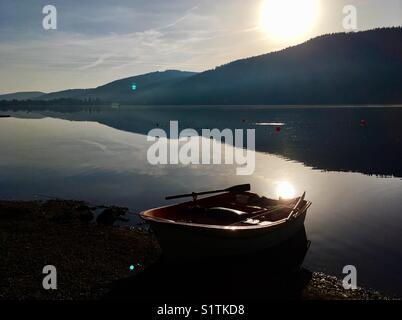 Petit bateau à rames sur les rives de la calme et paisible lac Titisee dans la Forêt Noire allemande, tôt le matin Banque D'Images