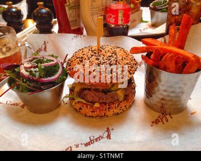 Burger, frites de patates douces et une salade. Banque D'Images