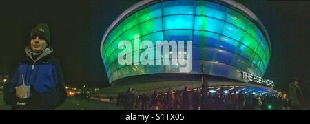 Garçon attendait dehors SSE Hydro Arena de Glasgow, Ecosse, par une nuit froide. Banque D'Images