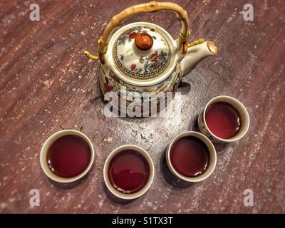 Pot de thé chinois avec quatre tasses de thé complet Banque D'Images
