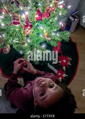 Un petit garçon se leva de son arbre de Noël. Banque D'Images