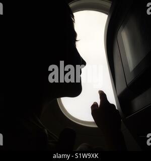 À l'enfant par la fenêtre dans un avion Banque D'Images