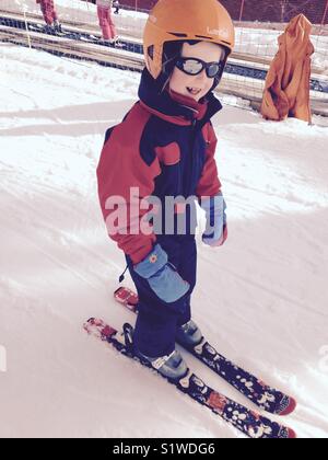 Fillette de 5 ans qui est le ski avec cycle libre, mais de seconde main, des vêtements élégants. Banque D'Images