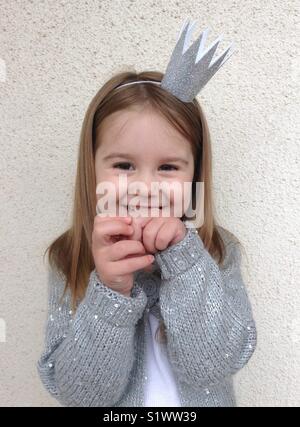 Happy smiling little girl wearing glitter hair band et sweater Banque D'Images