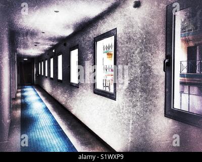 Biew un couloir sombre avec les bâtiments de l'autre côté de la route étroite vu à travers les fenêtres de vue, Funchal, Madeira, Portugal Banque D'Images