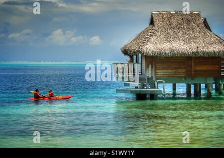 Couple miel matin kayak autour des Bungalo's à Bora Bora, Polynésie française. Banque D'Images