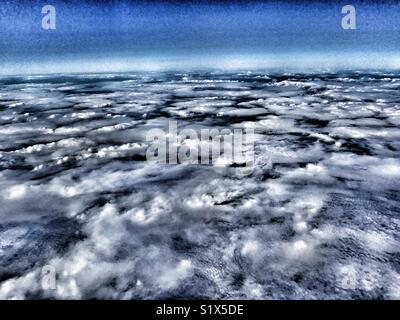 Vue par la fenêtre d'un avion volant au-dessus des nuages sur l'Océan Atlantique Banque D'Images