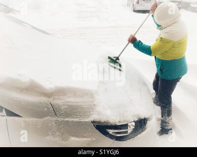 Nettoyage de l'homme dans sa voiture de la neige Banque D'Images