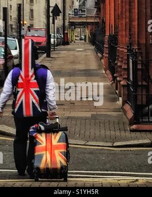 Man carrying Union Jack guitar case jaune et cas dans Knghtsbridge Londres. Banque D'Images
