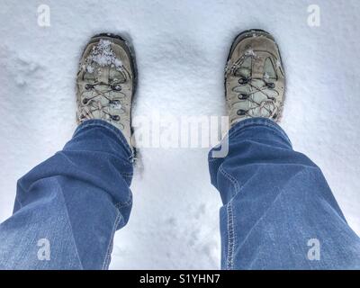 POV bottes de randonnée et jeans dans la neige fraîche Banque D'Images