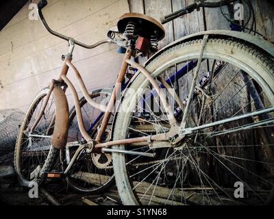 Deux vieilles bicyclettes mémorisé avec le fil du poulet dans le hangar Banque D'Images