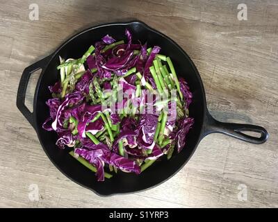 Le chou rouge et les asperges dans une poêle en fonte Banque D'Images