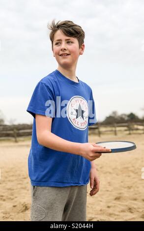 Un jeune garçon jouant au frisbee Frensham grand étang près de Farnham, dans le Surrey. Banque D'Images