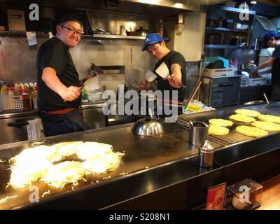 Deux hommes cuisiniers préparer la nourriture dans un restaurant japonais à Hiroshima. Banque D'Images