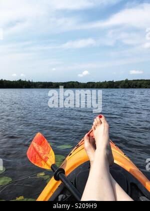 La dérive de détente sur un lac dans un kayak. Point de vue tourné. Banque D'Images