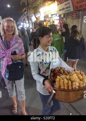 Deux femmes souriant à un marché de nuit à Ho Chi Minh City, Vietnam. Banque D'Images