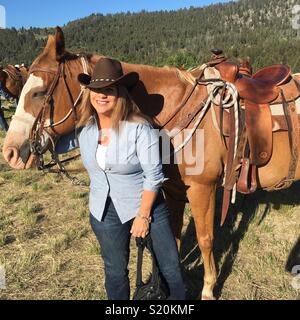 Une grande taille cowgirl et son cheval Banque D'Images